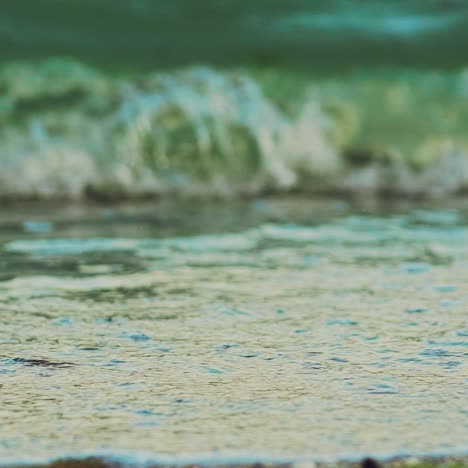 sea waves are splitting on a sandy shore in the summer. slow motion
