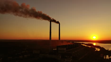 smokestack in factory with yellow cloudless sky. sunset above modern factory. panoramic video with drone.