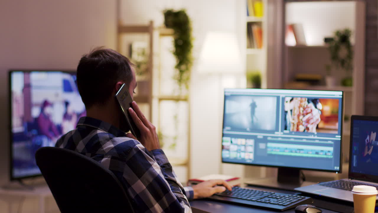 Man die achter zijn bureau een video bewerkt