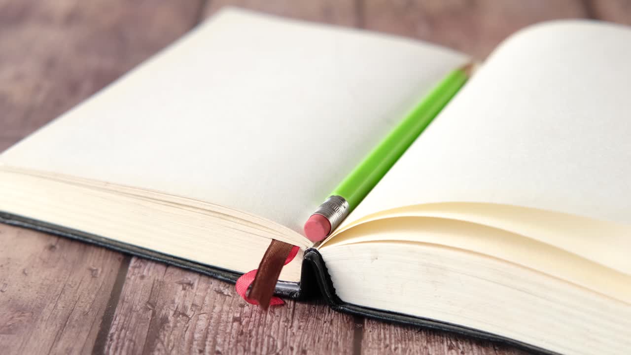 libro de notas abierto con lápiz verde