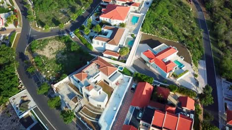 Tilt-up-aerial-view-of-the-luxury-homes-of-the-Blue-Bay-beach-in-Curacao,-Dutch-Caribbean-island,-deluxe-golf-resort