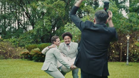 men in suits celebrating and taking photos in a garden