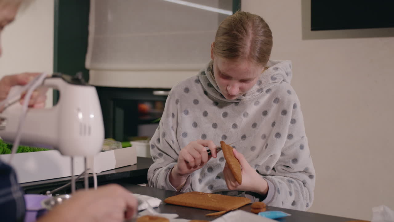 Nonna e nipote che costruiscono una casa di pan di zenzero