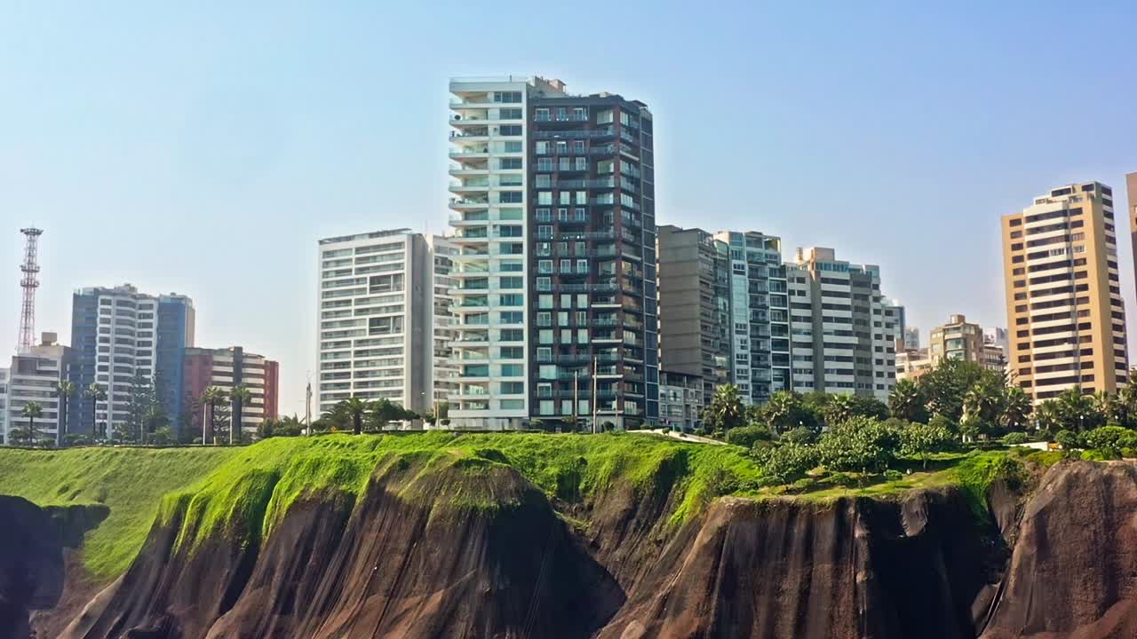 edificios modernos altos en lo alto de acantilados verdes cerca del océano en miraflores, lima, peru