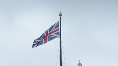 close up of british union jack flag flying over parliament in london, england
