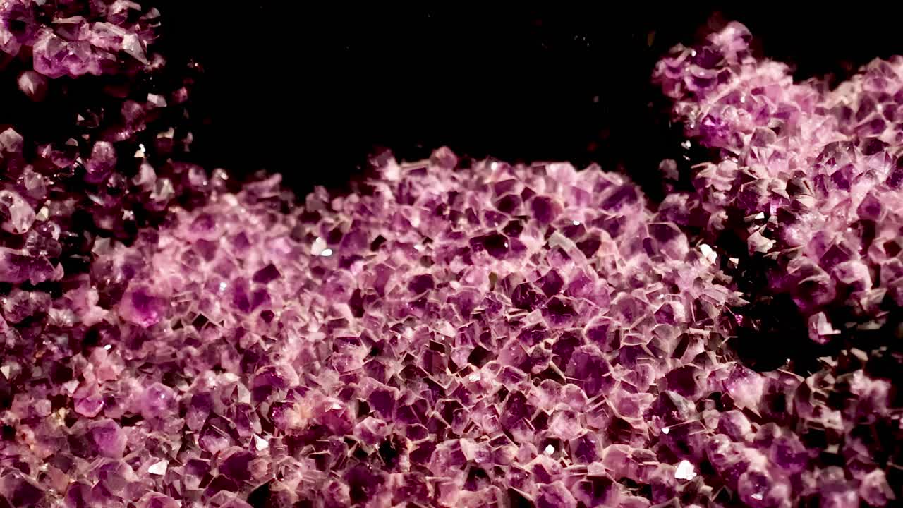 Detailed view of a vibrant purple crystal formation with intricate textures and sparkling facets.