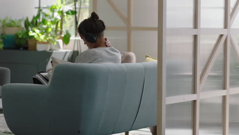 joven estudiante hispana escuchando música con auriculares disfrutando de estudiar en casa relajándose bebiendo café