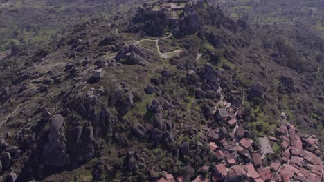 Reveal-shot-of-famous-village-Monsanto-at-Portugal-during-day-time,-aerial