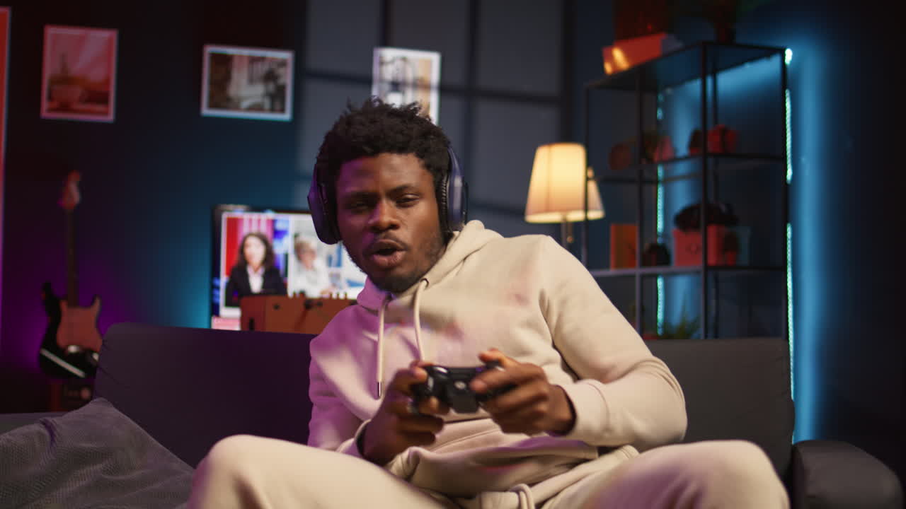 African american man plays intense online video games at home, spamming attack buttons on his controller. Gamer participating in online competition, playing on gaming console. Camera B.
