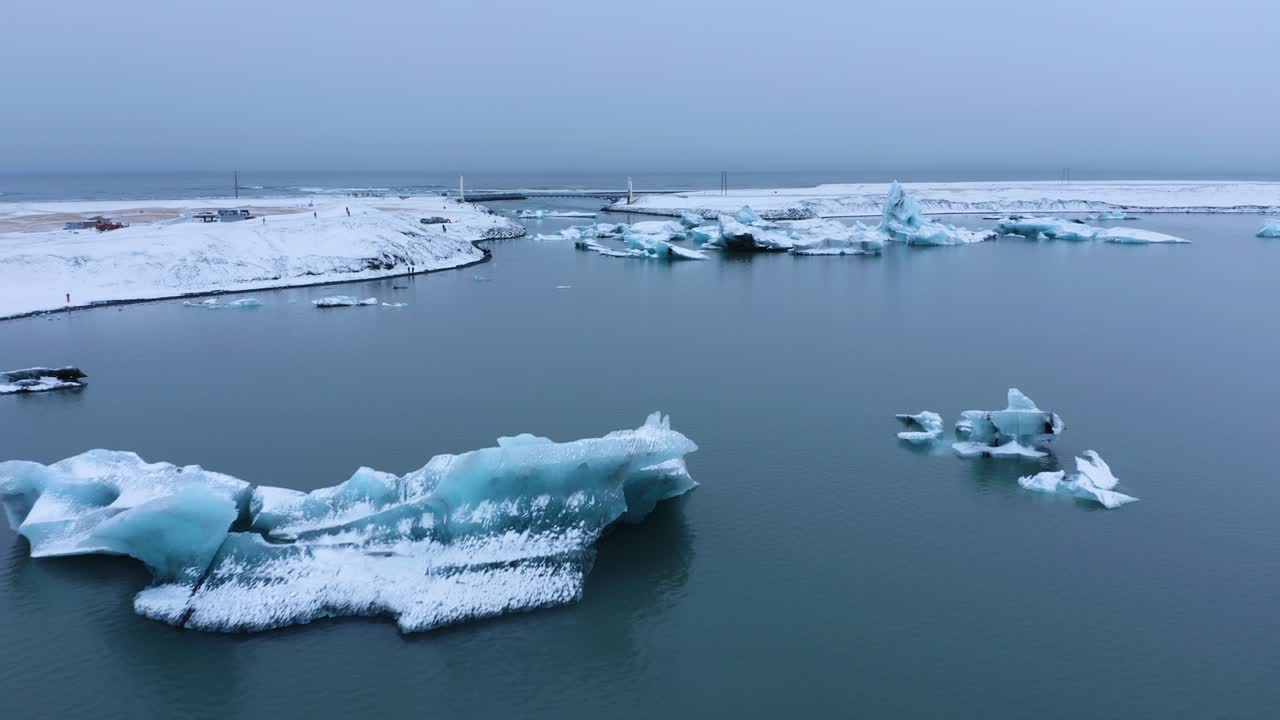 toma aérea de drones del lago glaciar islandés con icebergs nevados durante la nube gris en el cielo - jo kulsa rlo n en islandia - concepto de calentamiento global