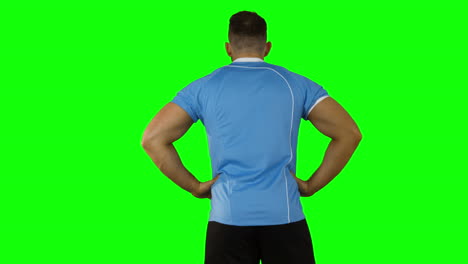 serious rugby player on green background