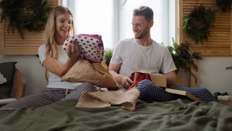 happy couple opening christmas gifts