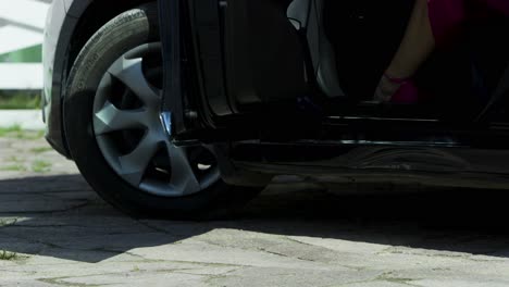 woman in pink heels stepping out of a car