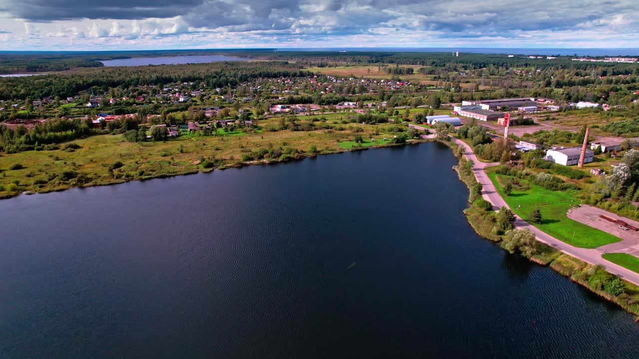 Aerial view of a lake and villages in Latvia under a cloudy sky