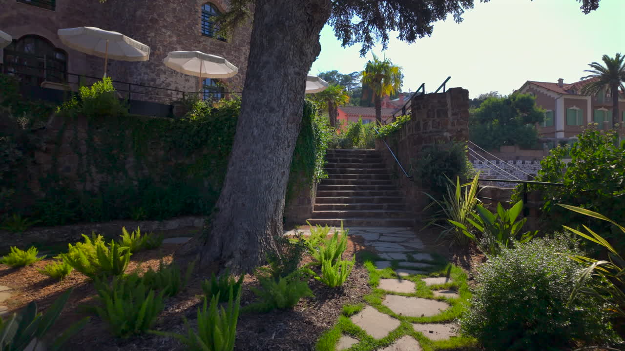 Greenery surrounding a pathway in the courtyard of the Chateau de Theoule-sur-Mer, France