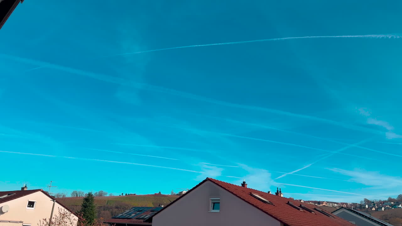 Water vapor forms in the air and causes white streaks to appear in the sky, panning shot