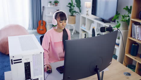 Teen-girl-with-headphones-sitting-at-desk-at-home