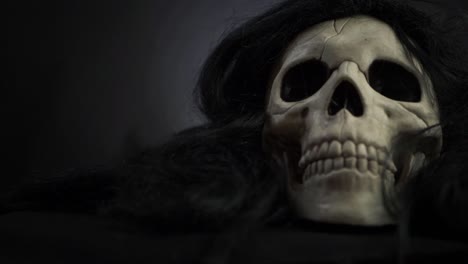 Creepy-skull-with-black-hair-on-dark-background-medium-panning-shot