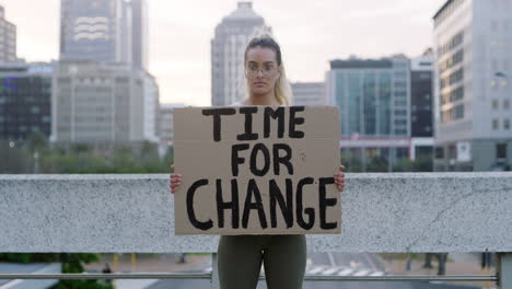 woman holding 'time for change' sign in urban setting