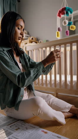 mother assembling baby crib and educational toys