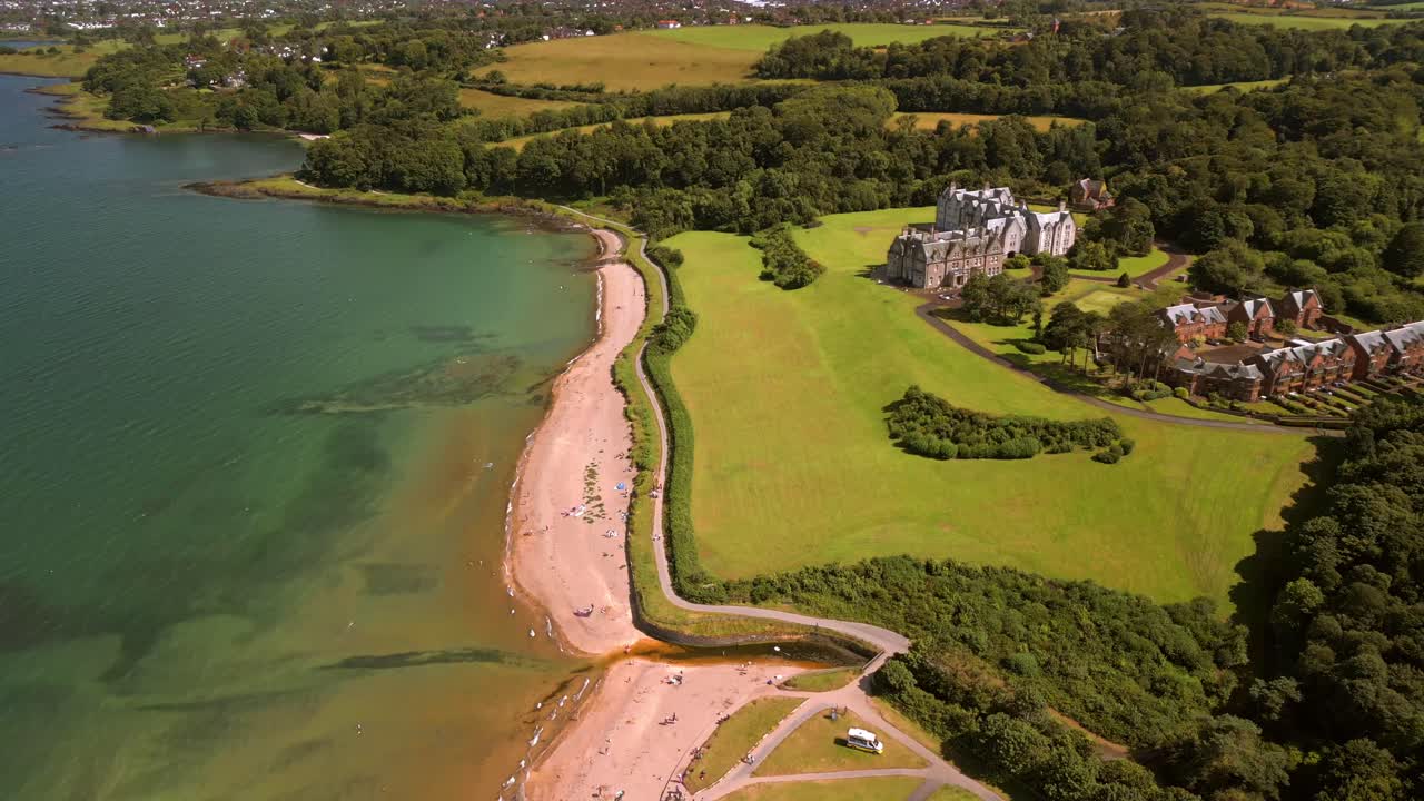 Widea advancing aerial video of Helen's Bay beach in County Down, Northern Ireland, UK on a bright summer day. Filmed in 4K, 60FPS and with Rec709 color