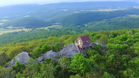 rise-up aerial parallax shot of fire watch tower and vlaley