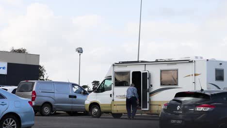 man approaches and enters a motorhome