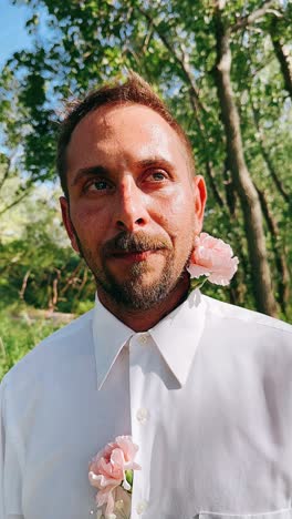 man with pink carnation in park