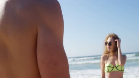 pareja de pie en la playa en un día soleado 4k