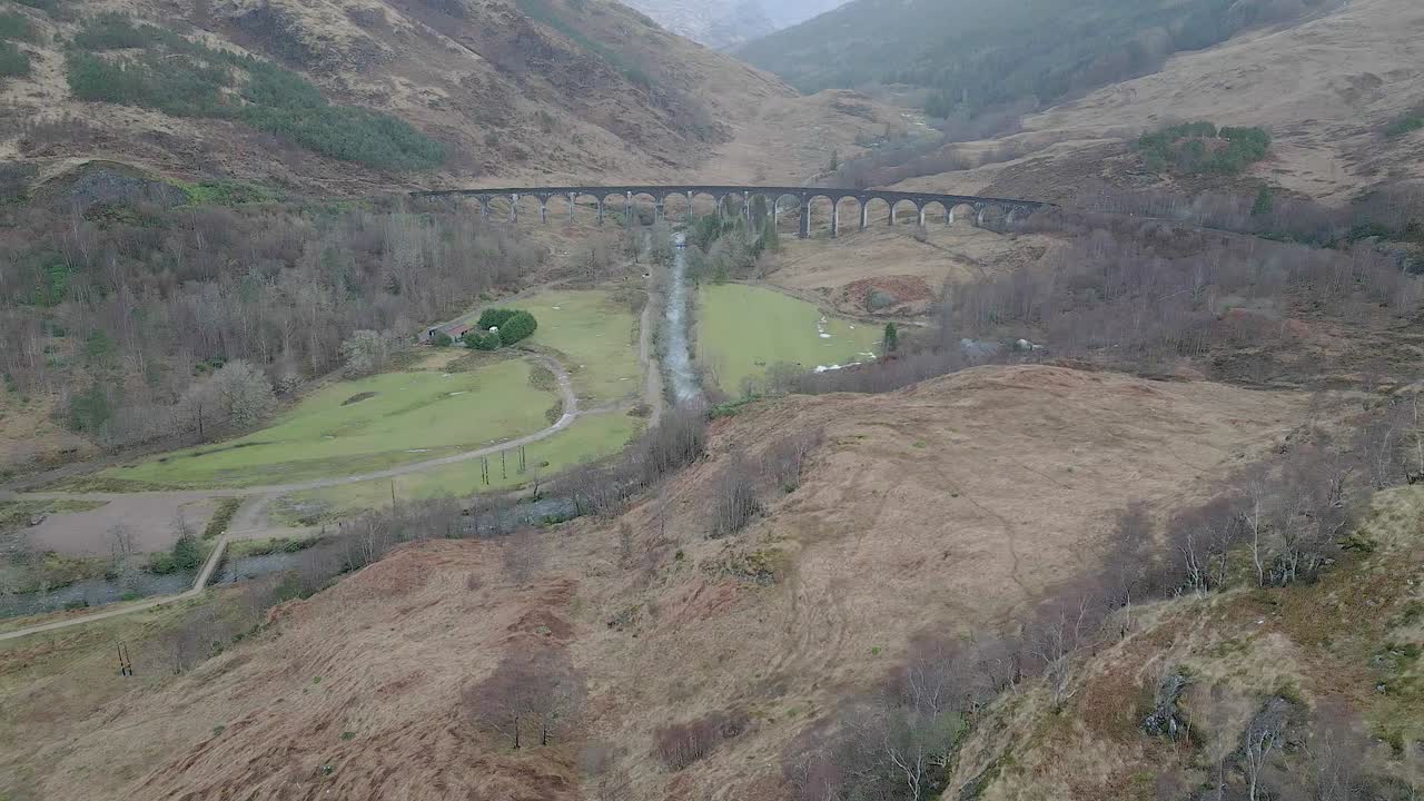 스코틀랜드의 역사적인 glenfinnan viaduct, 경치와 초록색 언덕에 둘러싸여, 공중에서 볼 수 있습니다.
