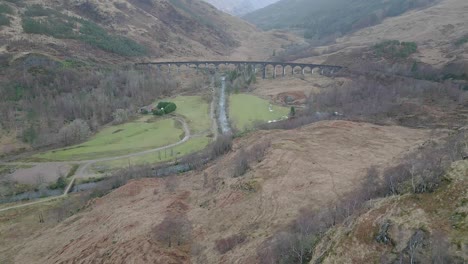 the historic glenfinnan viaduct in scotland, surrounded by scenic landscapes and verdant hills, aerial view