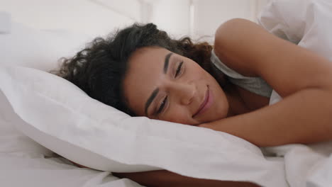 beautiful mixed race woman waking up in bed after restful sleep smiling happy ready for new day feeling fresh 4k footage