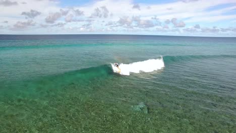 un hombre va a surfear en maldivas