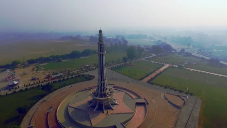 aerial rotating view of minar-e-pakistan against the sun, a national monument located in lahore, pakistan