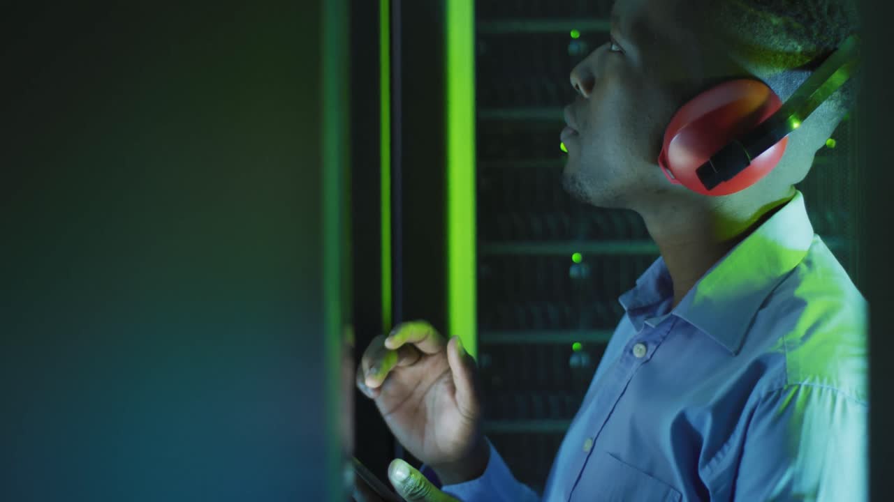 técnico de computadoras afroamericano que usa una tableta trabajando en una sala de servidores de negocios