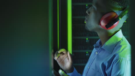 African-american-male-computer-technician-using-tablet-working-in-business-server-room