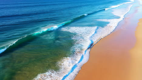 aerial view of ocean waves breaking on a sandy beach