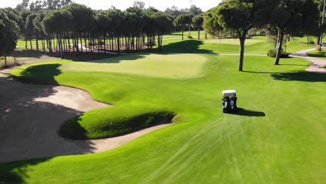 Flying-over-and-following-golf-cart-in-golf-course-field,-Turkey