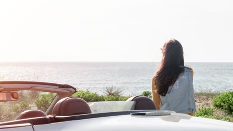 couple enjoying a scenic beach drive in a convertible