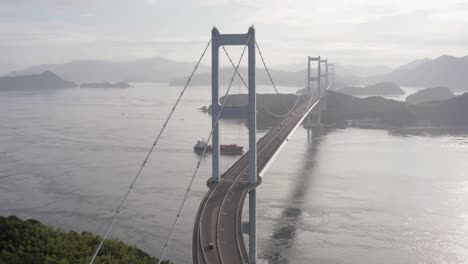 barco pasando por debajo del puente colgante kurushima kaikyo, japón