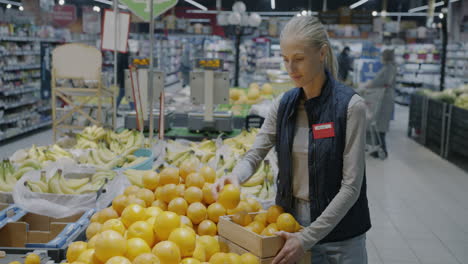 woman shopping for oranges in a grocery store