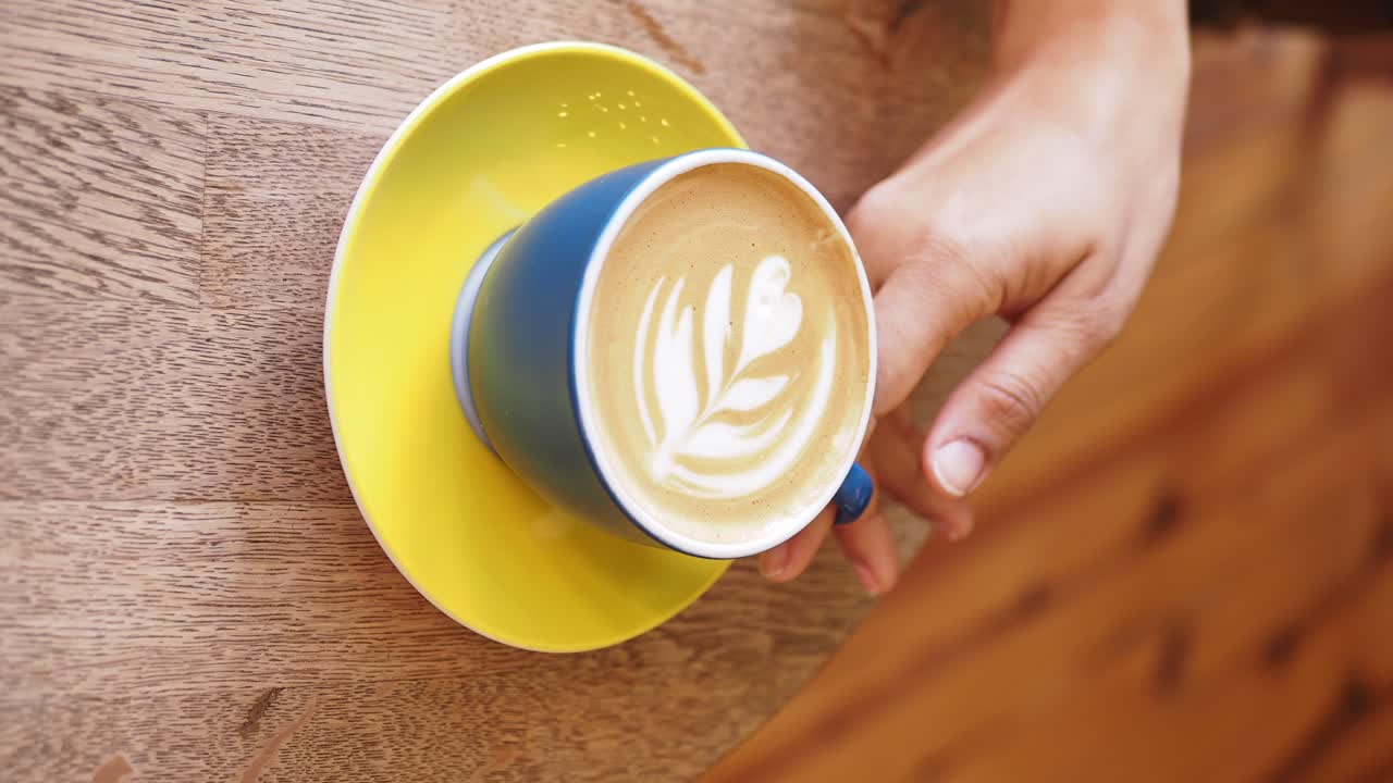 나무 테이블 위에 라테 예술의 컵