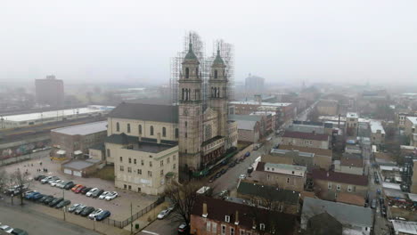 Aerial-view-of-a-truck-driving-in-front-of-the-St-Adalbert's-Catholic-Church,-in-Pilsen,-Chicago,-USA