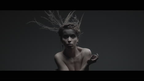 a woman dressed as mother nature moves slowly in a dance-like motion