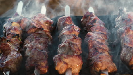 closeup pork kebabs cooking on grill outdoor. grilling smoked bbq.