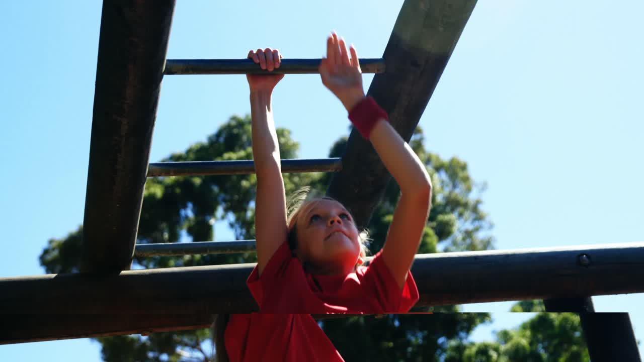 Girl climbing on monkey bar in the boot camp