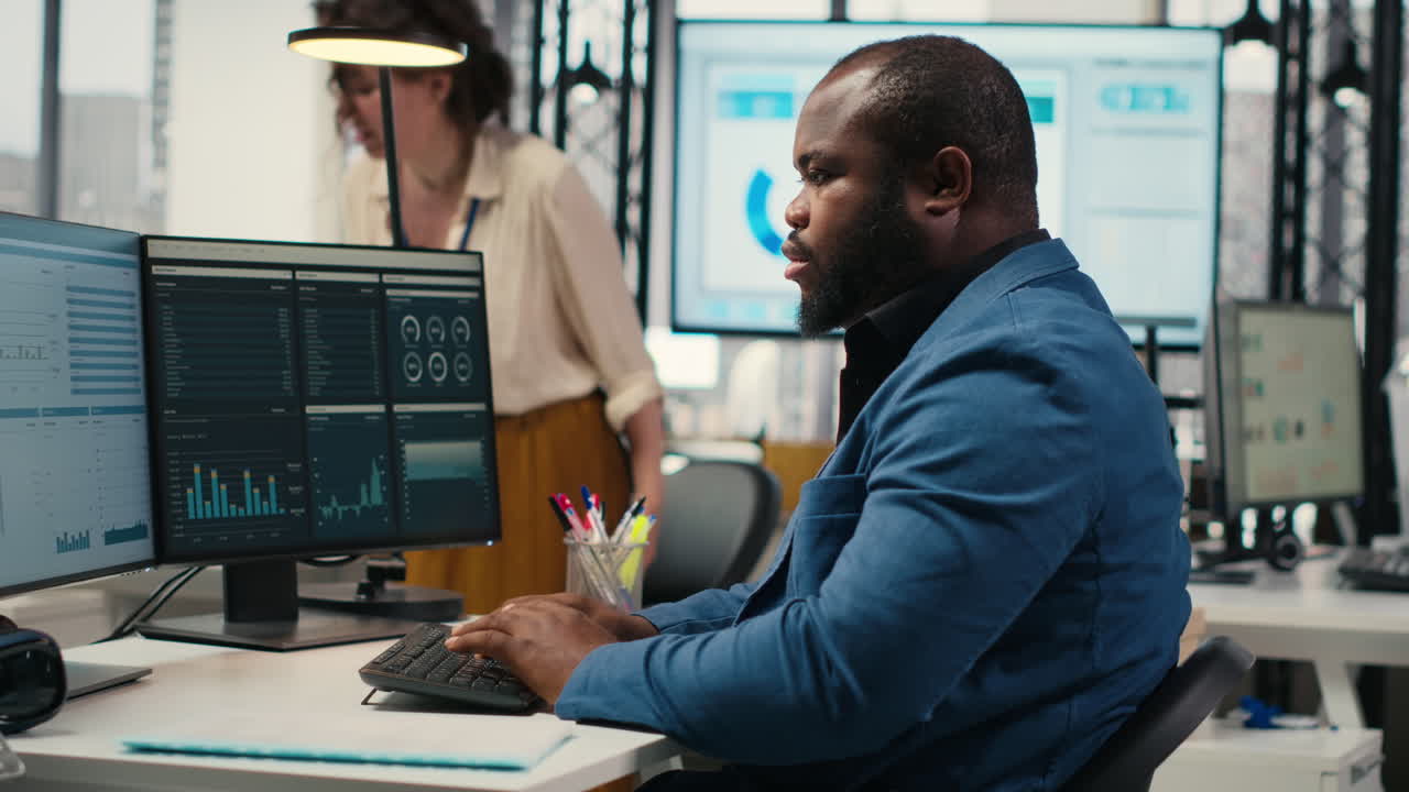 Vertical Video Black male administrator in modern workspace analyzing forecast insights