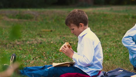 young-guy-reads-book-eating-burger-during-lunch-break