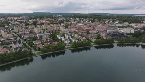 Pequeña-Ciudad-De-Motala-En-Suecia-Con-Hermosas-Casas-En-La-Orilla-Del-Océano,-Panorámica-Aérea