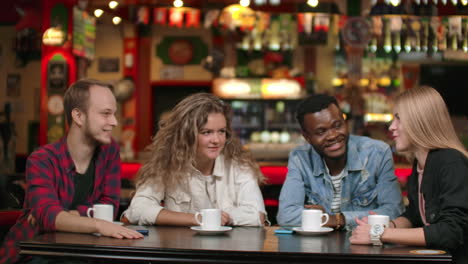 a multinational company of friends drinks coffee and talking in a restaurant